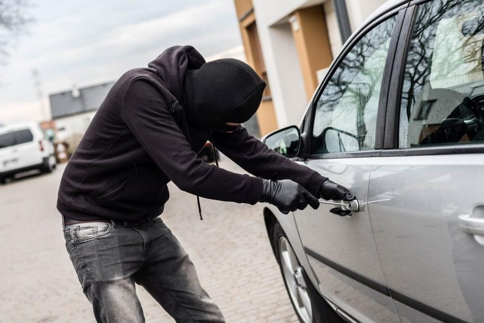 personne cagoulée ouvrant une voiture